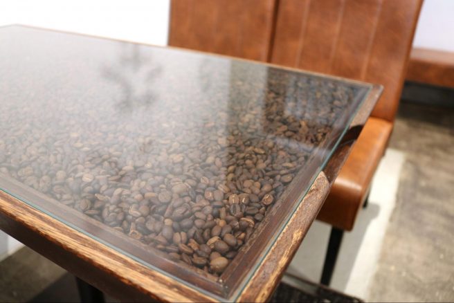 コーヒー豆が敷き詰められたガラストップテーブル