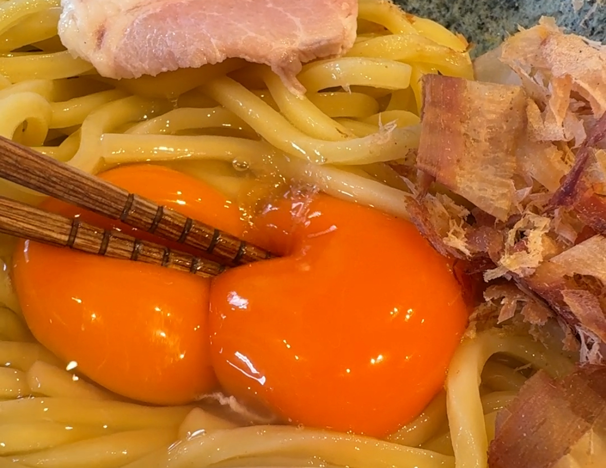 Crushing two egg yolks with chopsticks